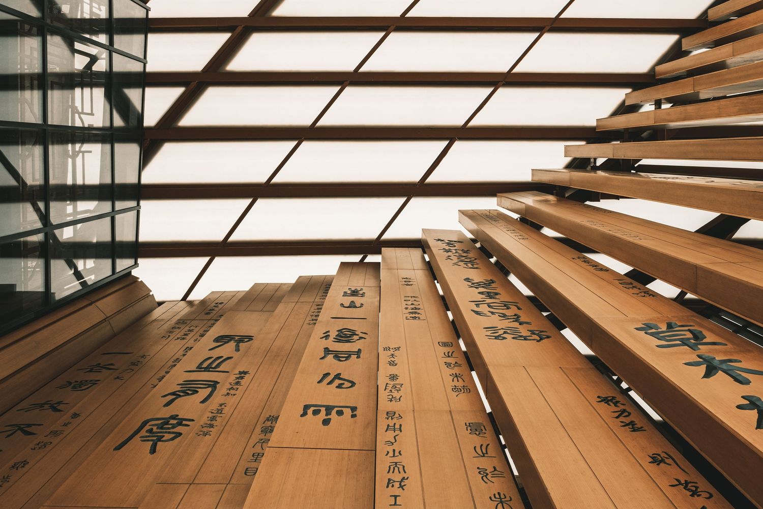 Angular view of wooden panels with Chinese characters under industrial ceiling lighting. Interior Photography