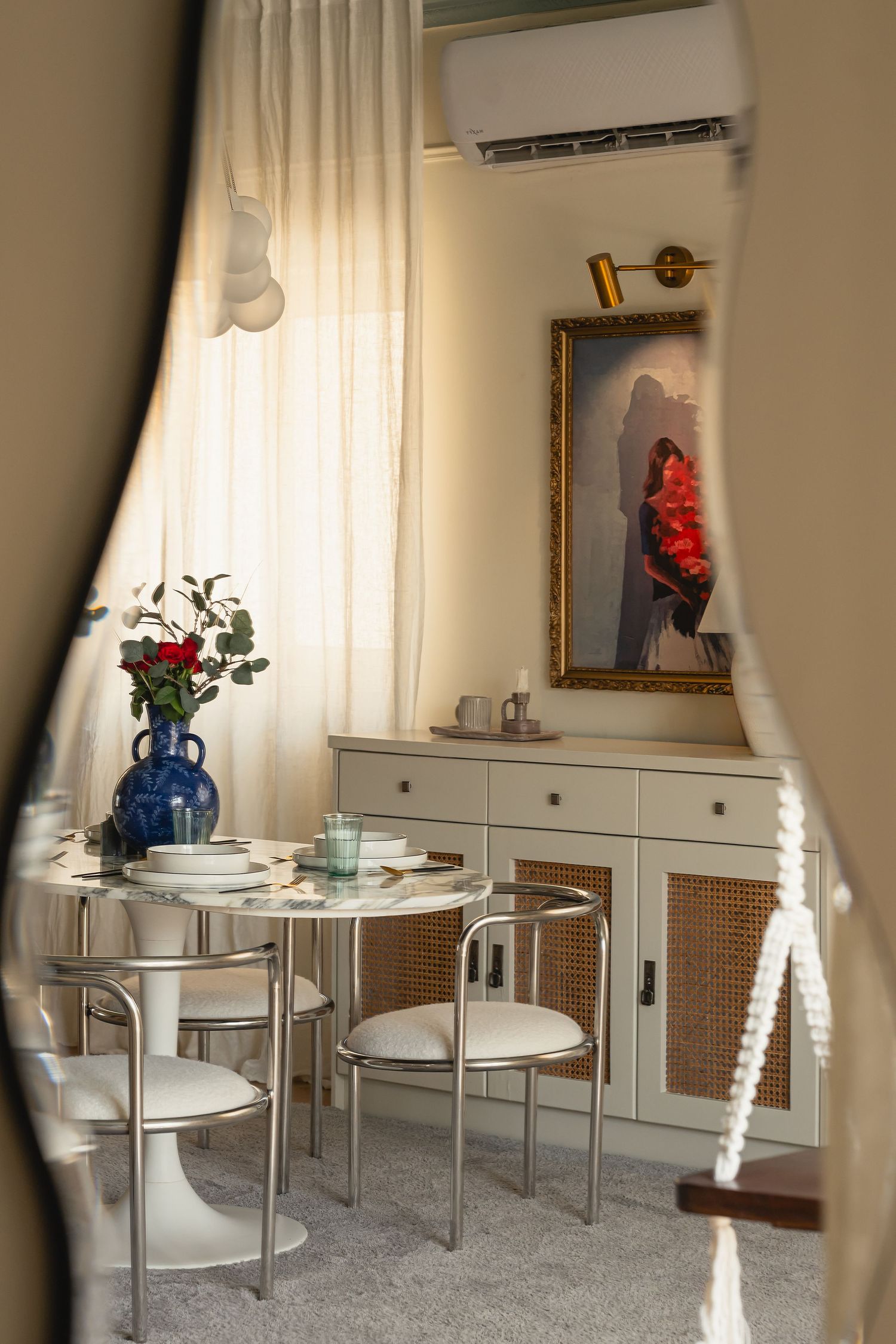 Modern dining space featuring round glass tables, white chairs and decorative blue vase with flowers. Interior Photography
