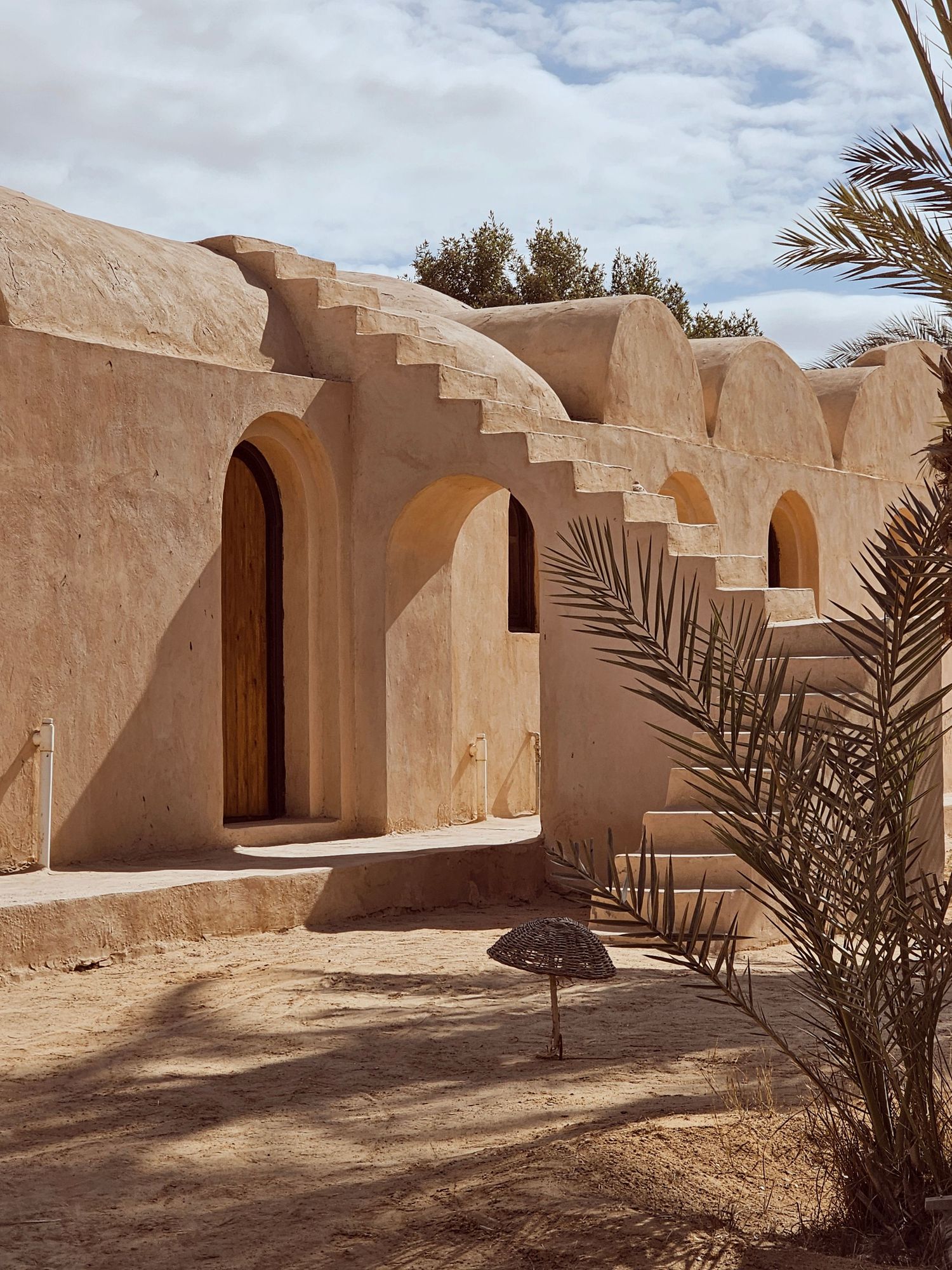 Traditional Middle Eastern architecture with stepped walls and arched doorways in sandy beige tones. Interior Photography