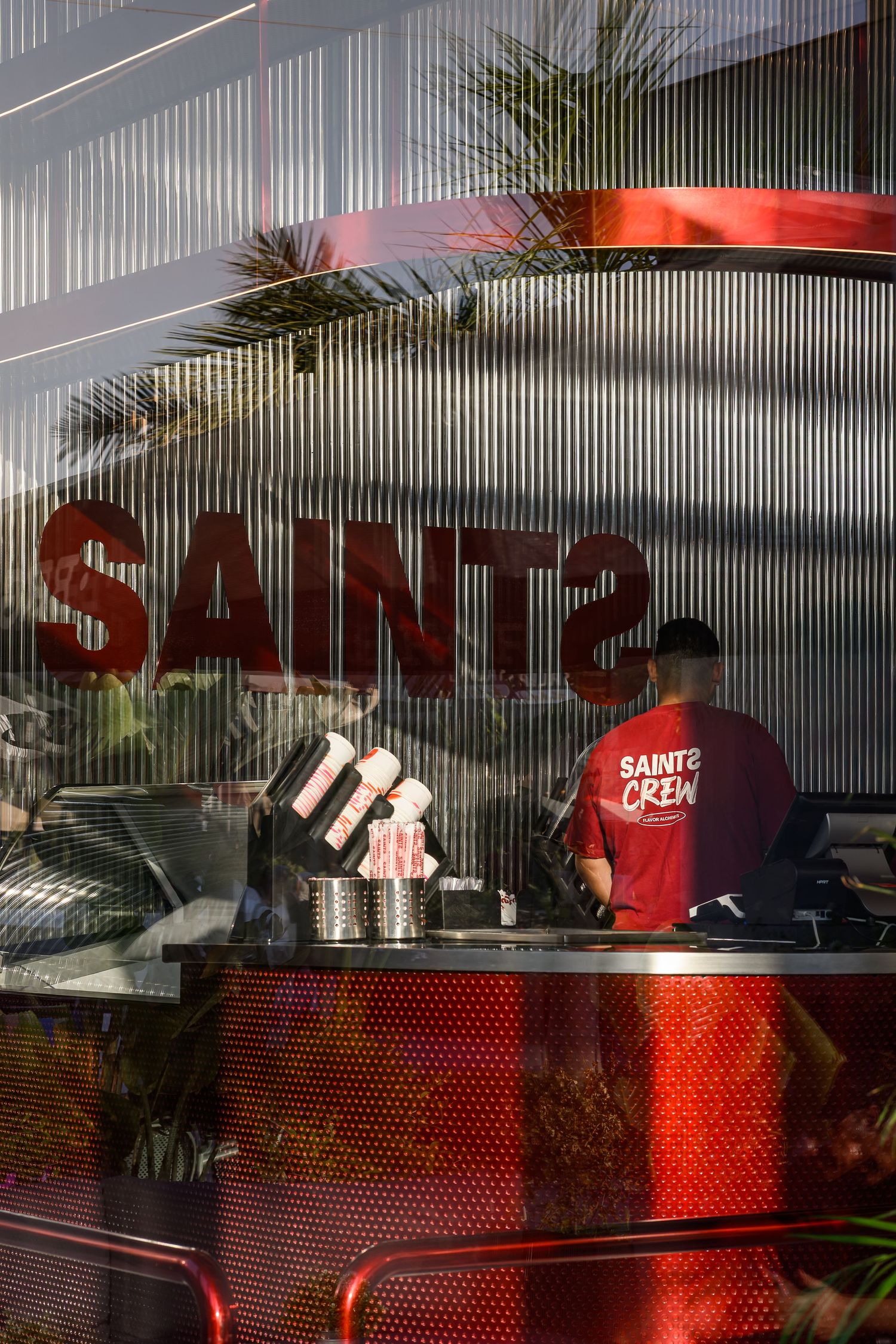 Modern restaurant exterior with red signage and metal paneling. Interior Photography
