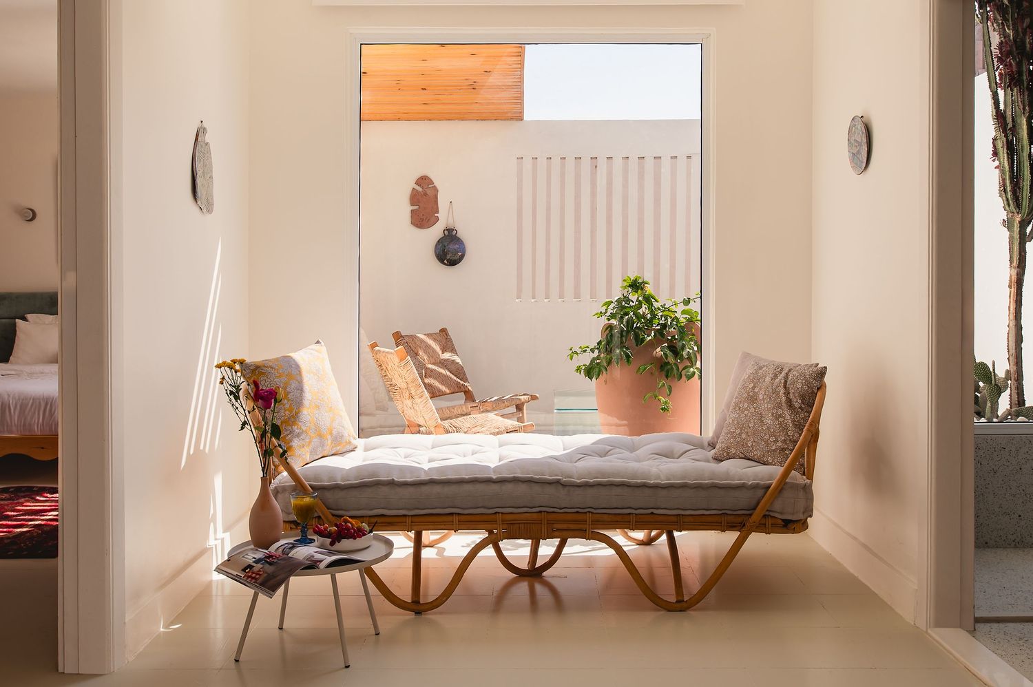 Minimalist hallway with rattan daybed and natural light streaming through window. Interior Photography