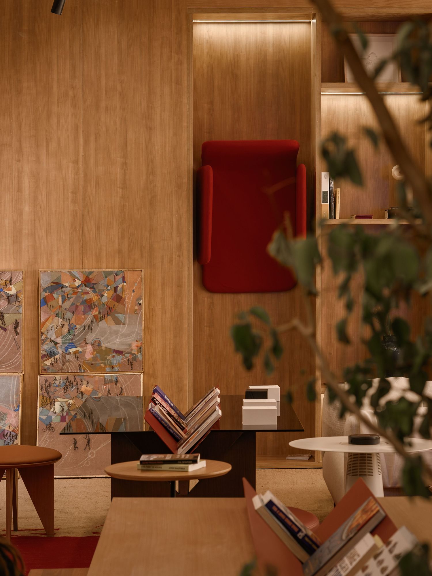 Cozy reading nook with wooden walls, vintage furniture, and artistic prints in warm lighting. Interior Photography