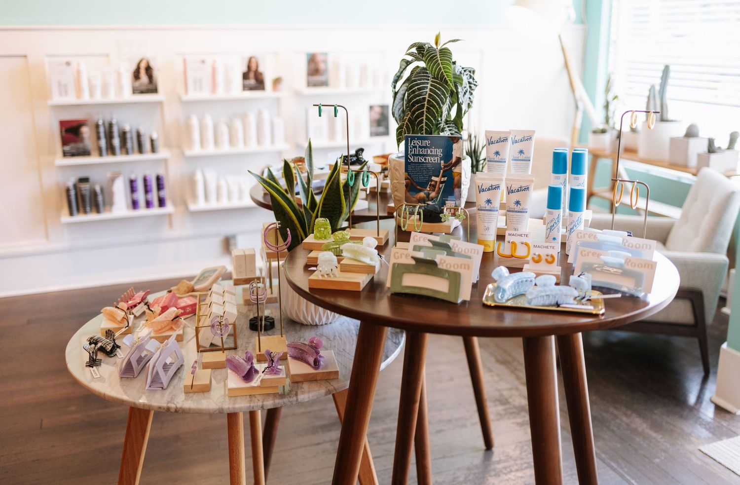 Modern retail display with beauty products arranged on round wooden tables.