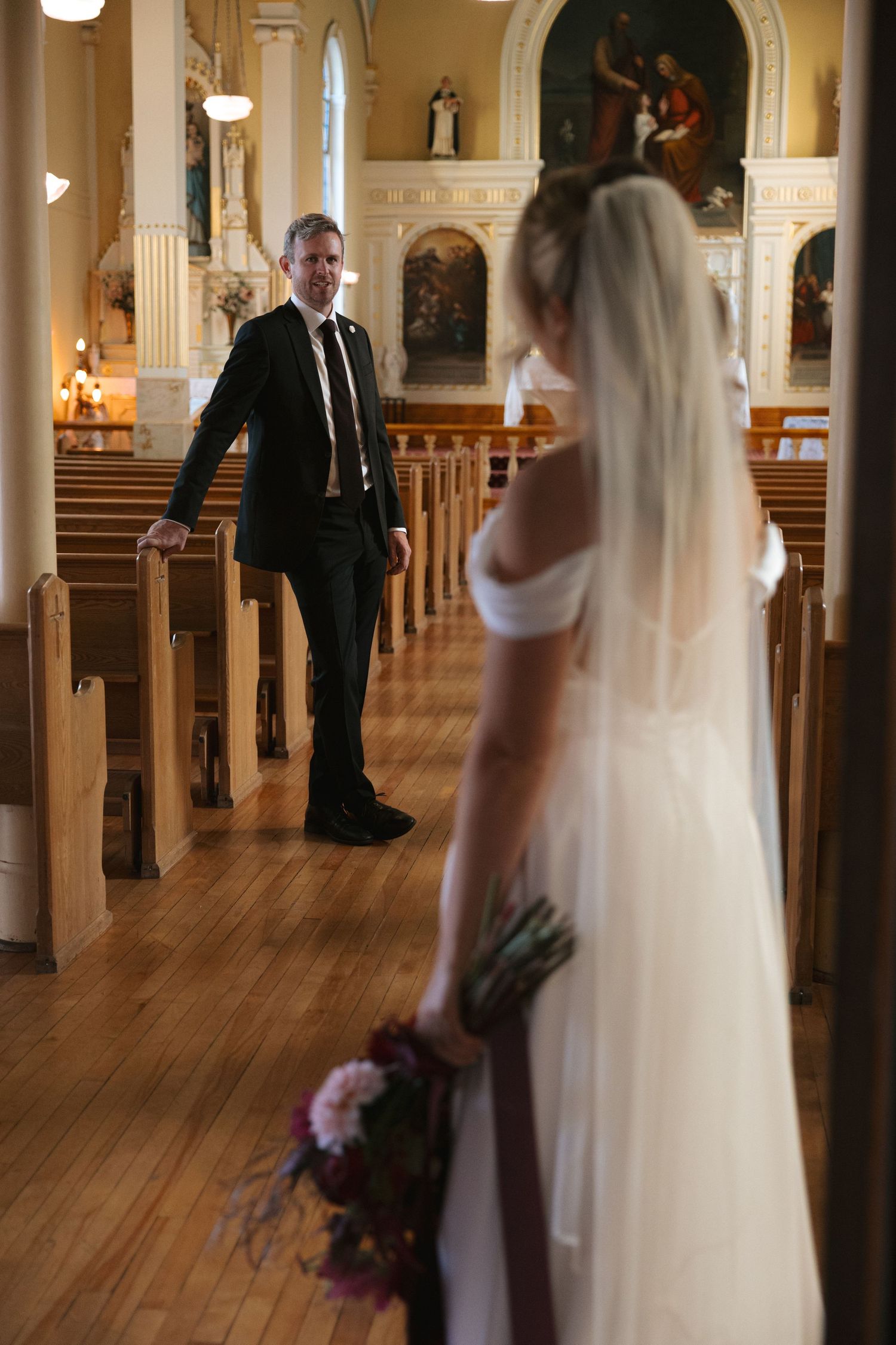A touching moment captured inside a traditional church with wooden pews and religious artwork adorning the walls.