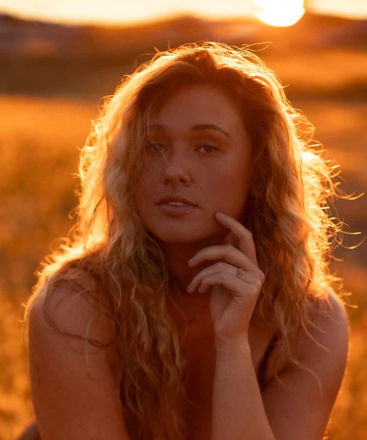 Backlit portrait in golden hour light with warm tones and soft focus effect.