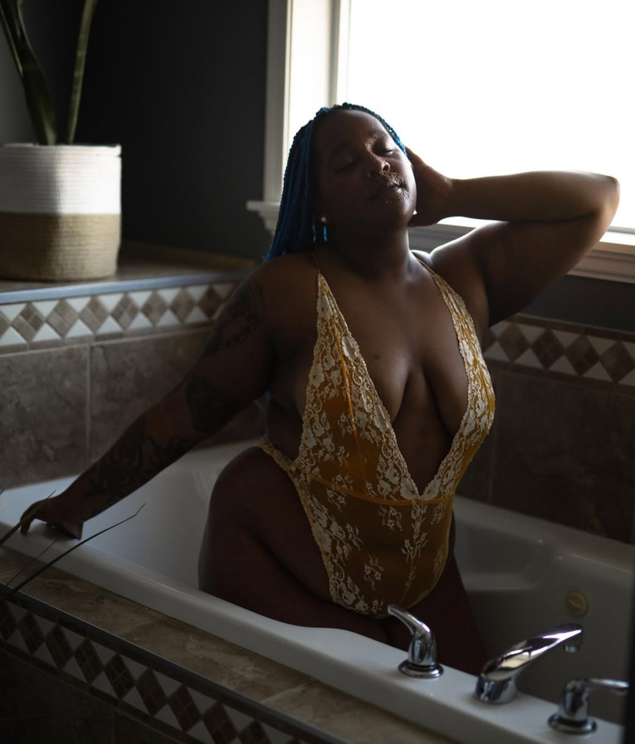 A person in a gold swimsuit relaxing in a luxurious bathtub.