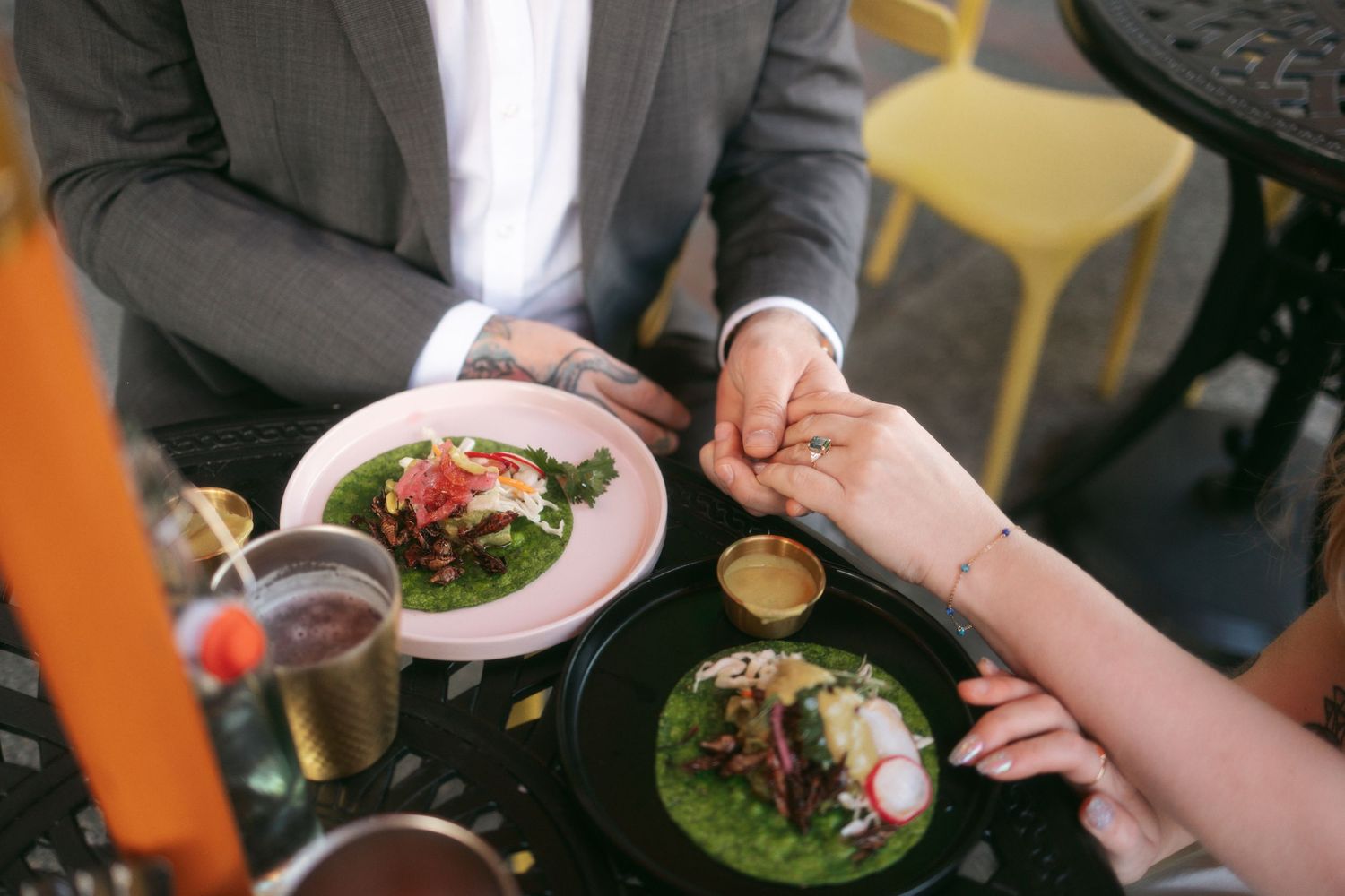 A series of hands holding plates with fresh salads and meals being presented in a restaurant setting.