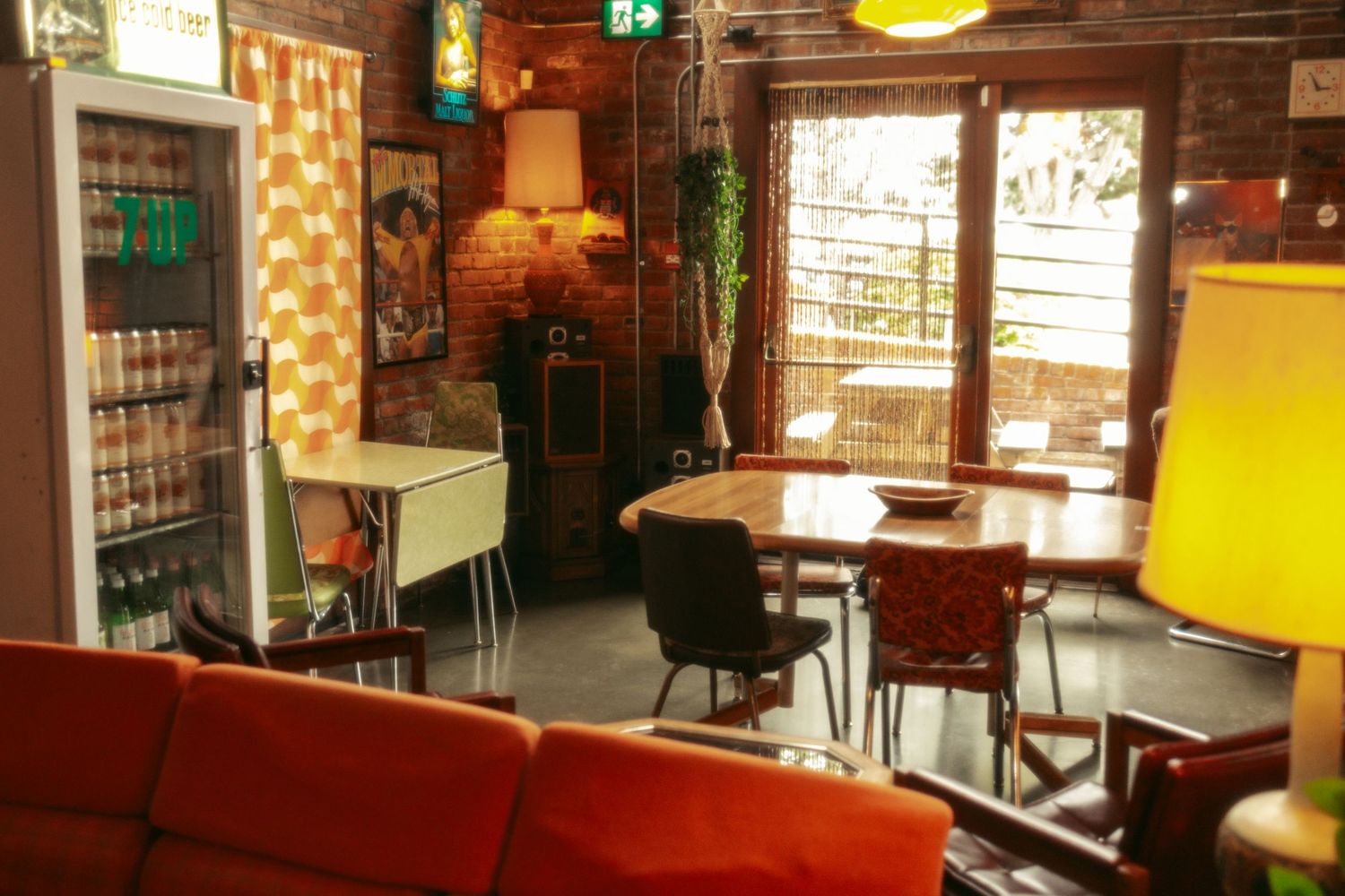 Interior view of a modern bar with exposed brick walls, pendant lighting, and red leather seating.