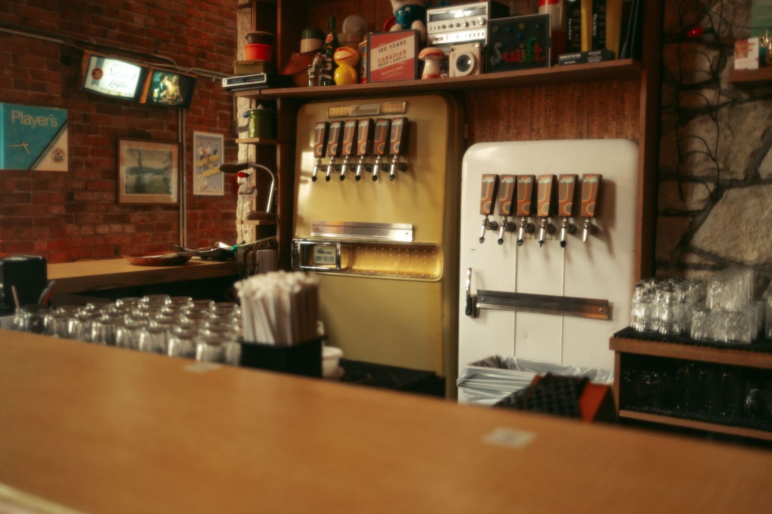 Interior view of a rustic pub showing wooden bar counter, beer taps, and warm ambient lighting.