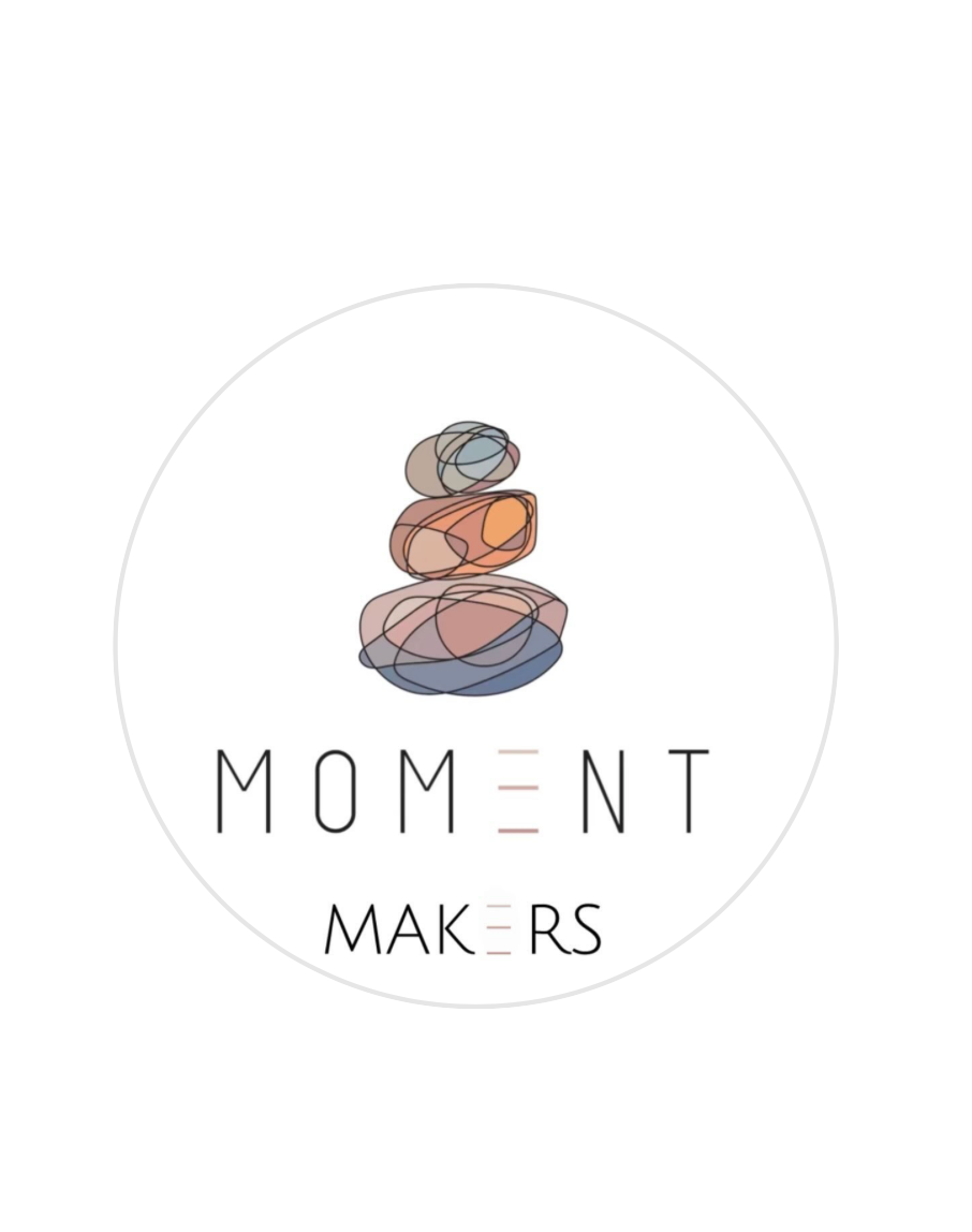 A circular logo design featuring stacked stones in soft colors with the text 'MOMENT MAKERS' underneath.
