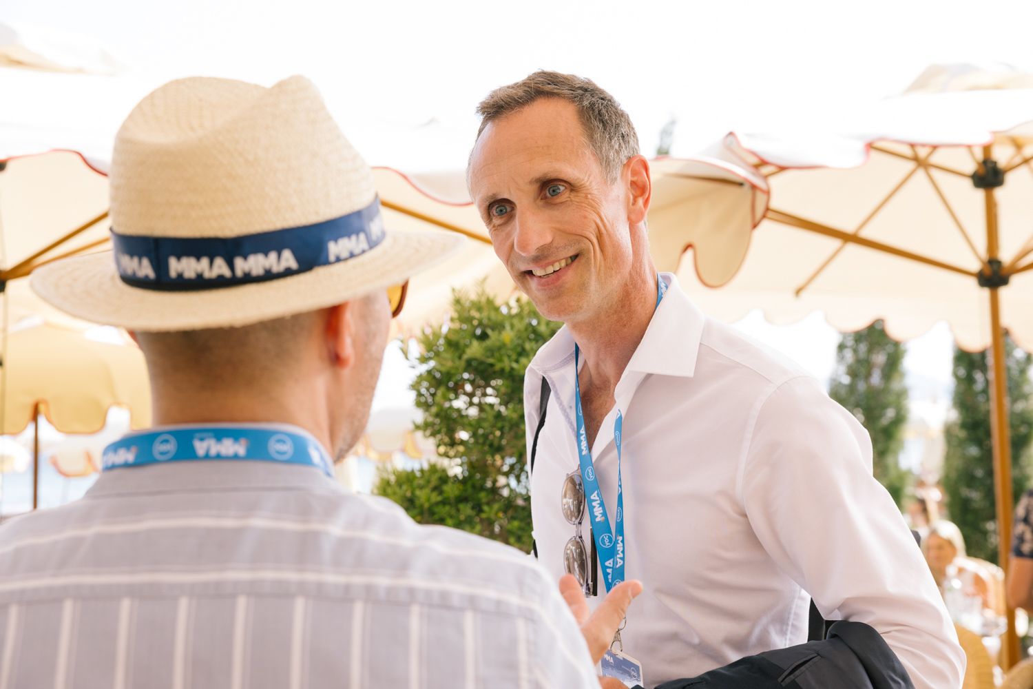 Business professionals engaging in conversation during an outdoor networking event.