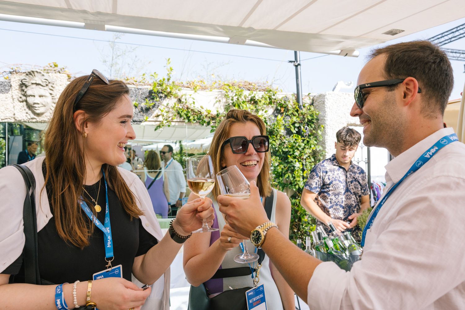 Group of professionals toasting with wine glasses at an outdoor networking event.