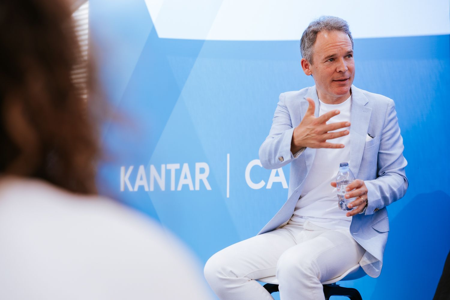 Professional speakers presenting at a business conference with Kantar CA branding visible in the background.