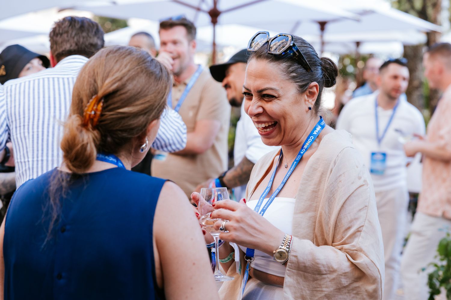 A group of guests mingling at an outdoor networking event with name badges.