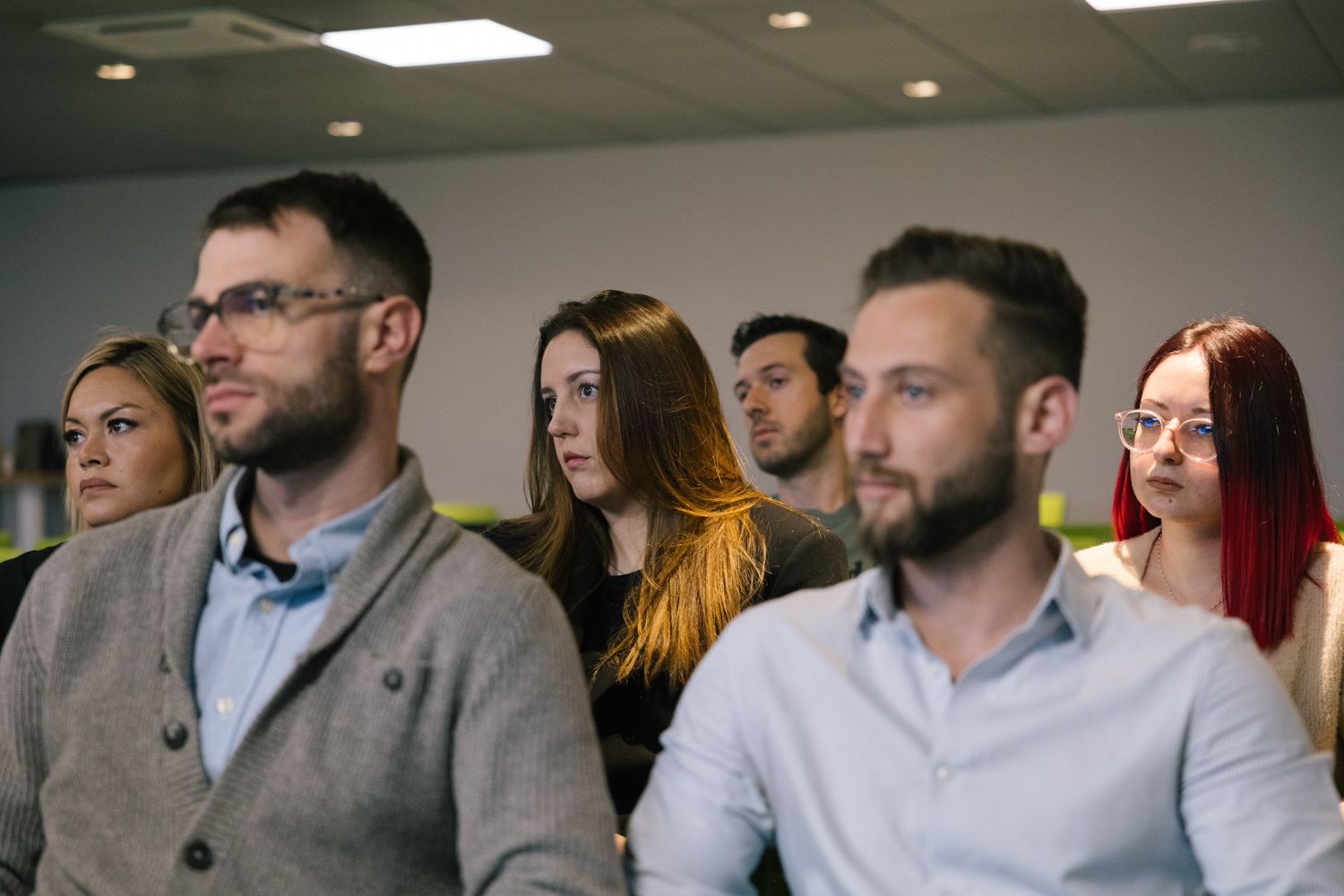 Professional audience members engaged in a business presentation or conference.