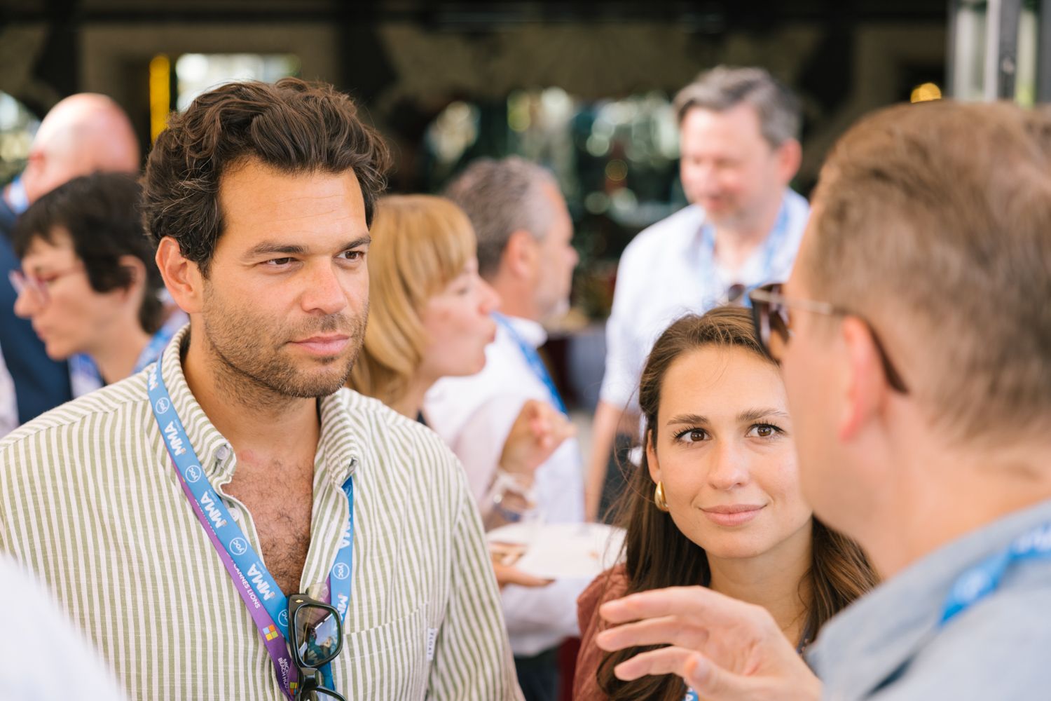 Attendees engage in conversation during an outdoor networking event.