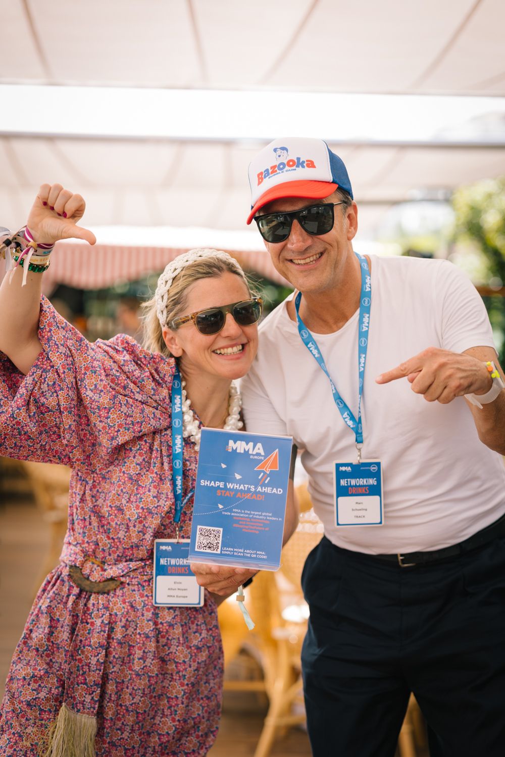 Event participants celebrating with MMA branded materials at an outdoor networking function.