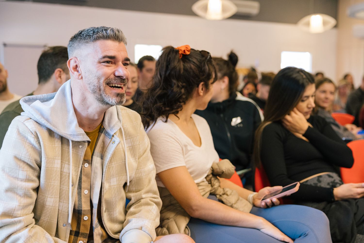 Conference attendees listen attentively during a presentation in a modern venue.