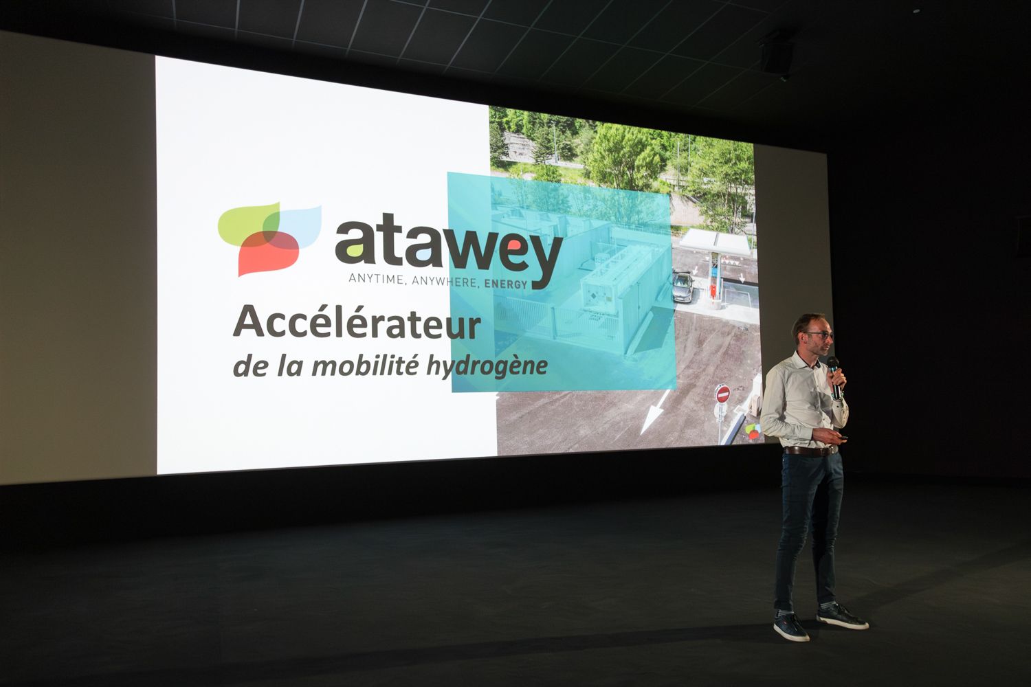 A presentation slide showing the Atawey company logo and tagline on a large projection screen.