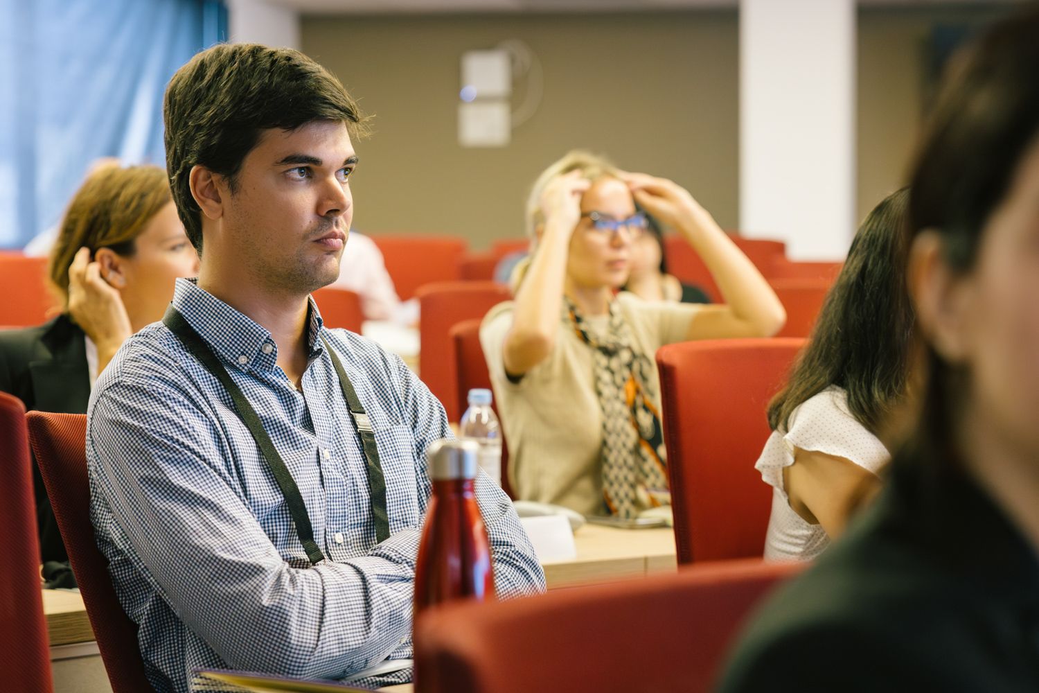 Students focused during business class lecture in auditorium.