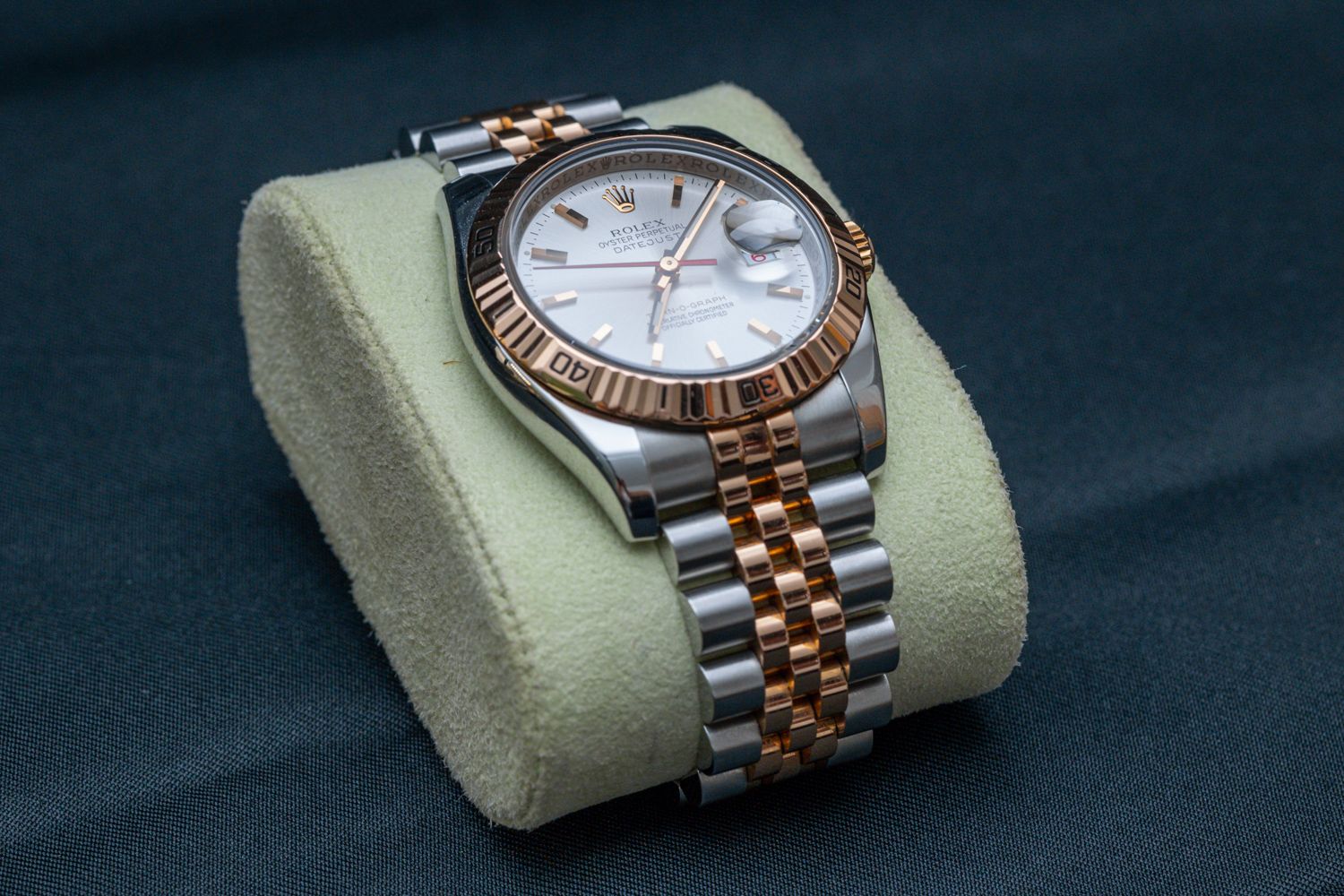 Two-tone luxury watch with jubilee bracelet displayed on a light-colored cushion.