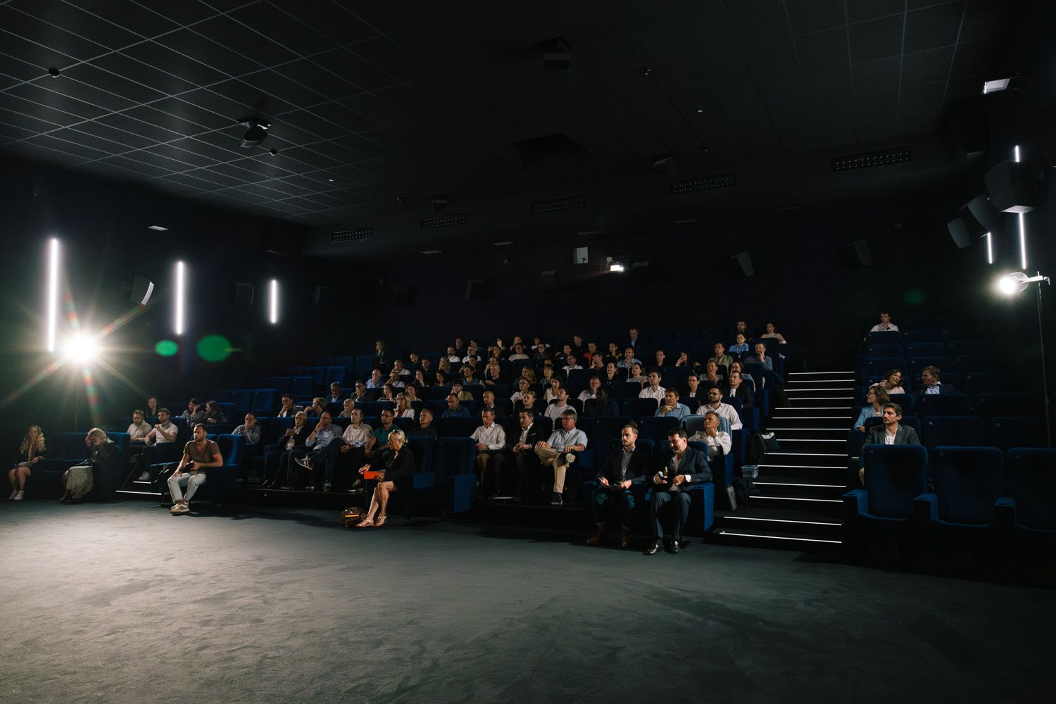Audience seated in dark theater during Solutions Climate conference presentation.