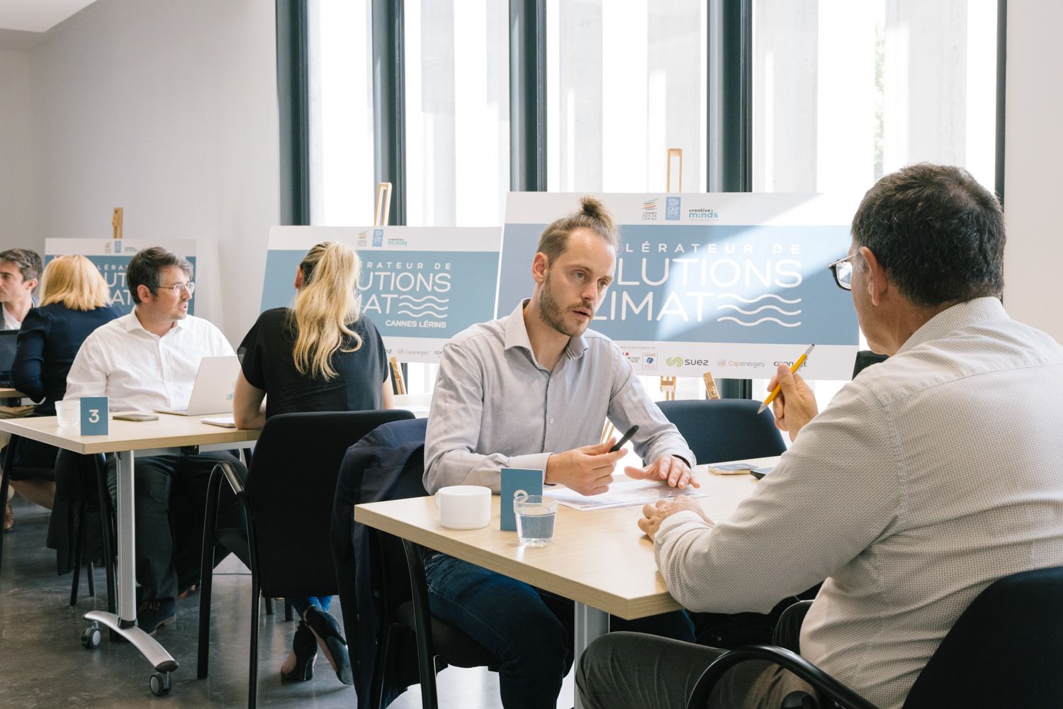 Business professionals engaged in discussion at modern office meeting space.