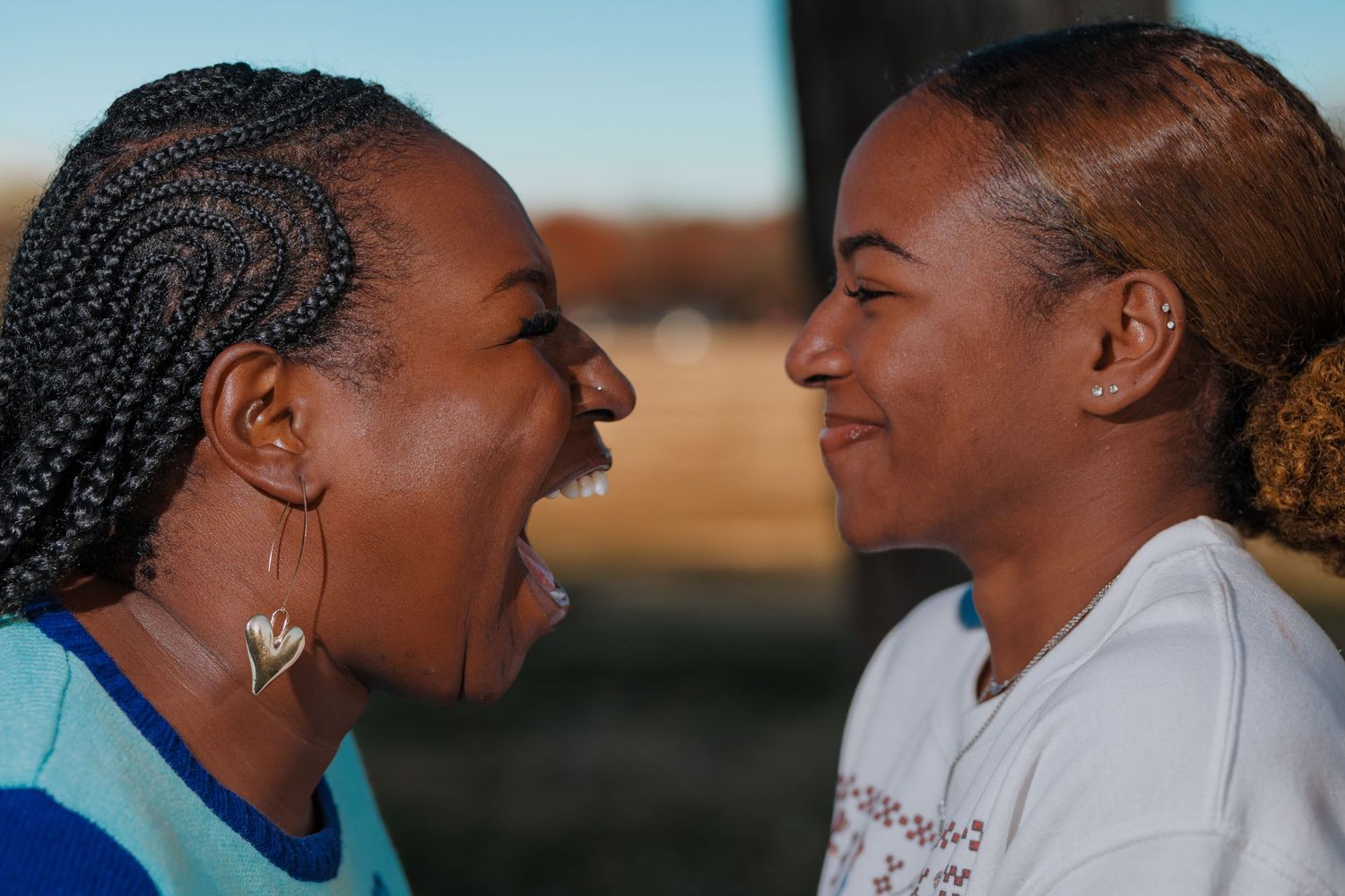 Two people sharing a joyful laughing moment outdoors.