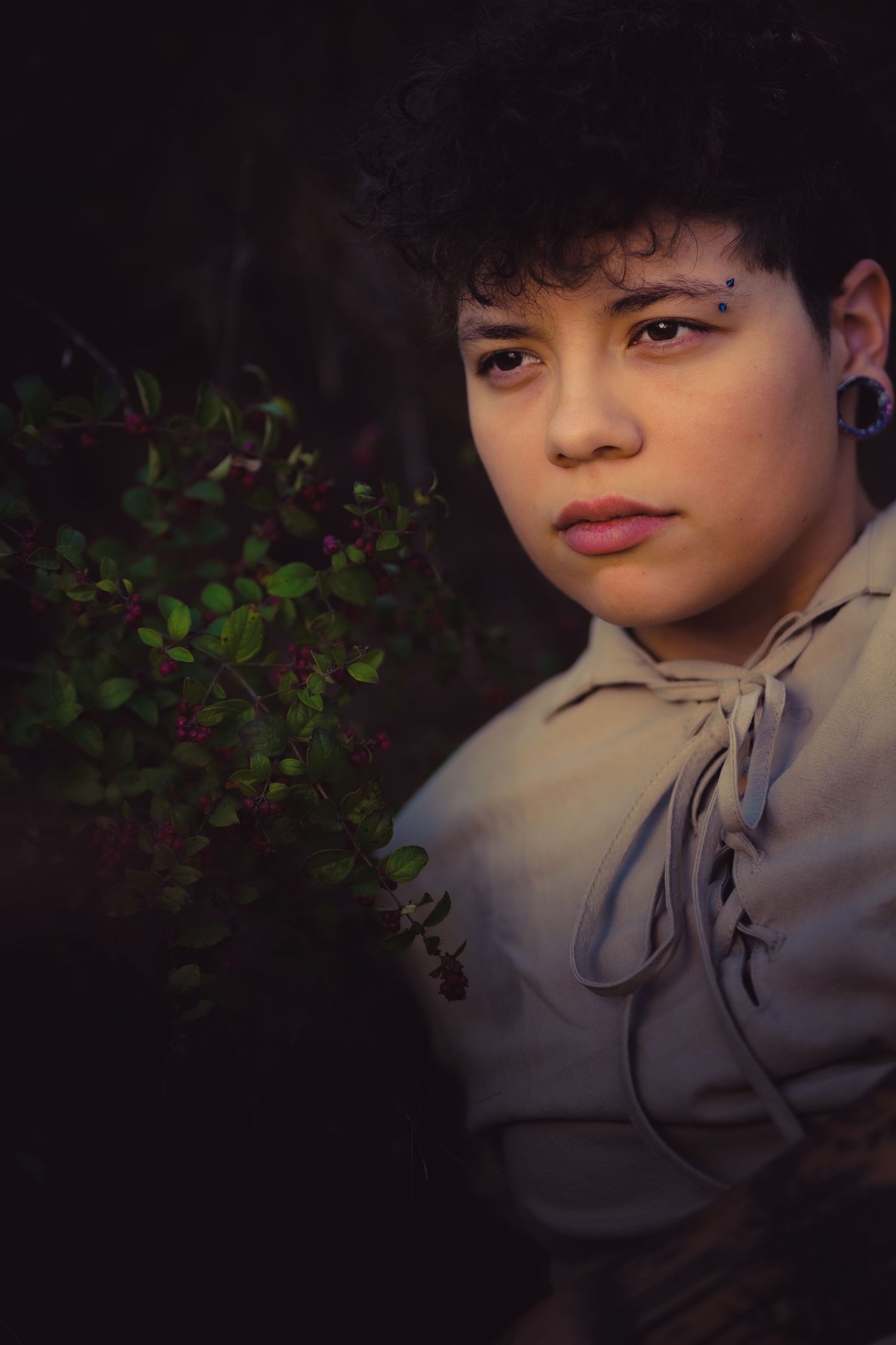 A moody portrait with vintage styling against dark foliage background.