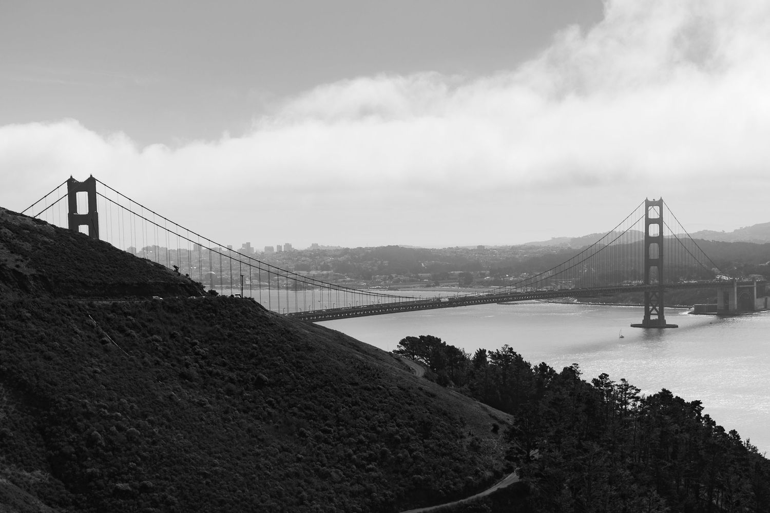 Black and white landscape of Golden Gate Bridge spanning San Francisco Bay.
