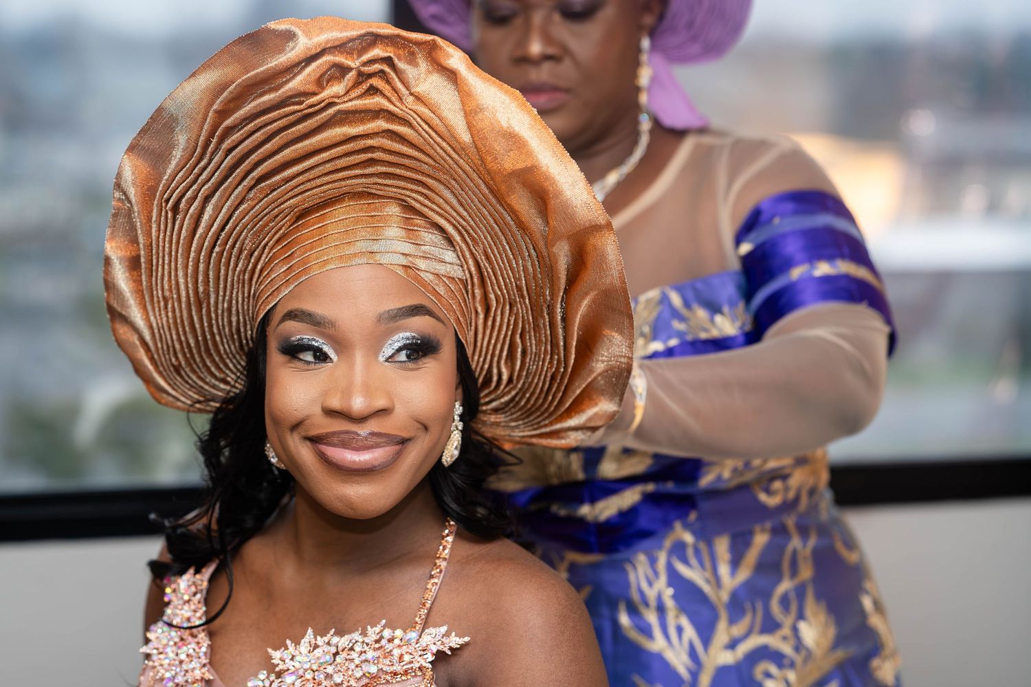 Close-up of intricate copper-colored gele headdress styling.