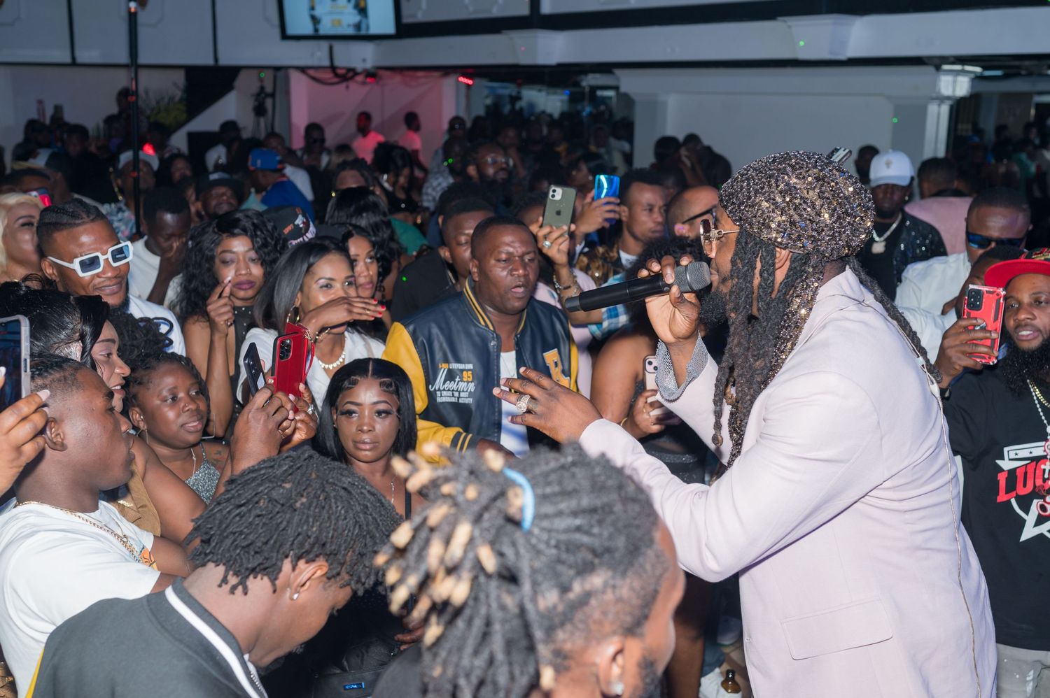Energetic crowd enjoying a lively performance at a nightclub venue.