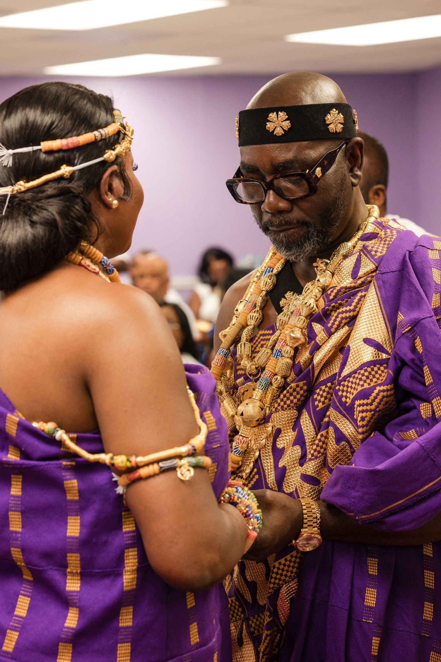Traditional ceremony with participants in purple and gold ceremonial dress.