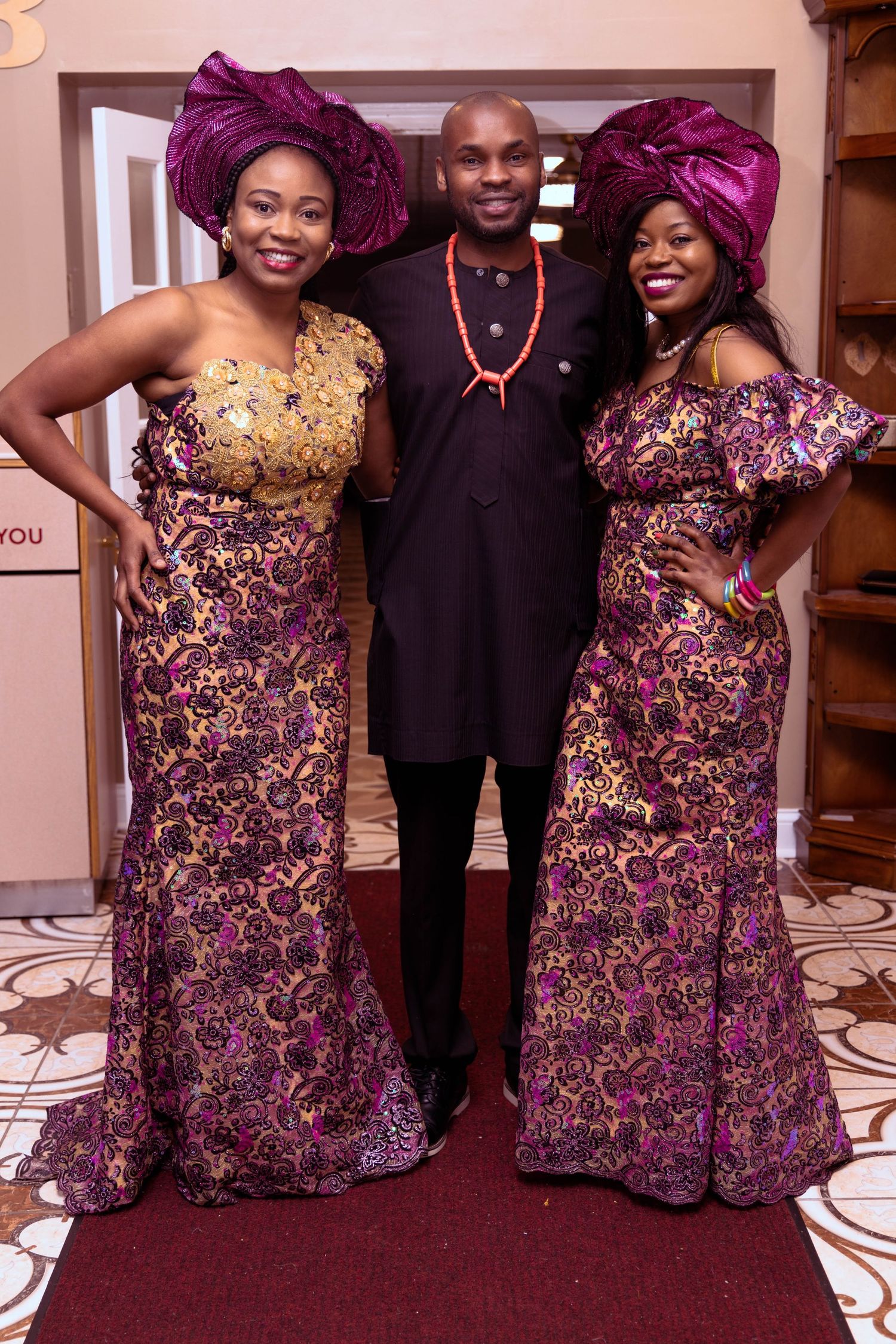 Elegant celebration featuring attendees in purple and gold formal African attire.