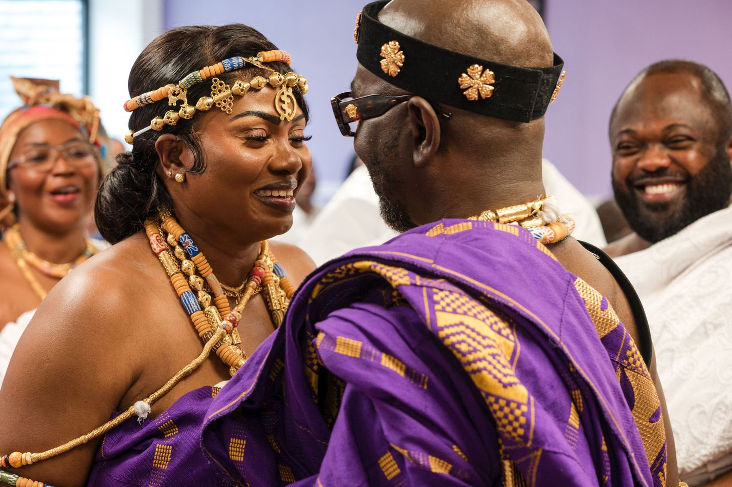 Traditional celebration with participants wearing purple and gold ceremonial attire.