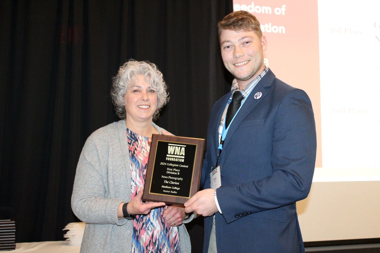 Award presentation ceremony showing plaque handoff on stage.