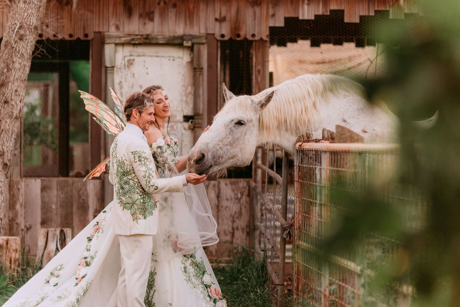 Romantic countryside wedding portrait with rustic barn setting.
