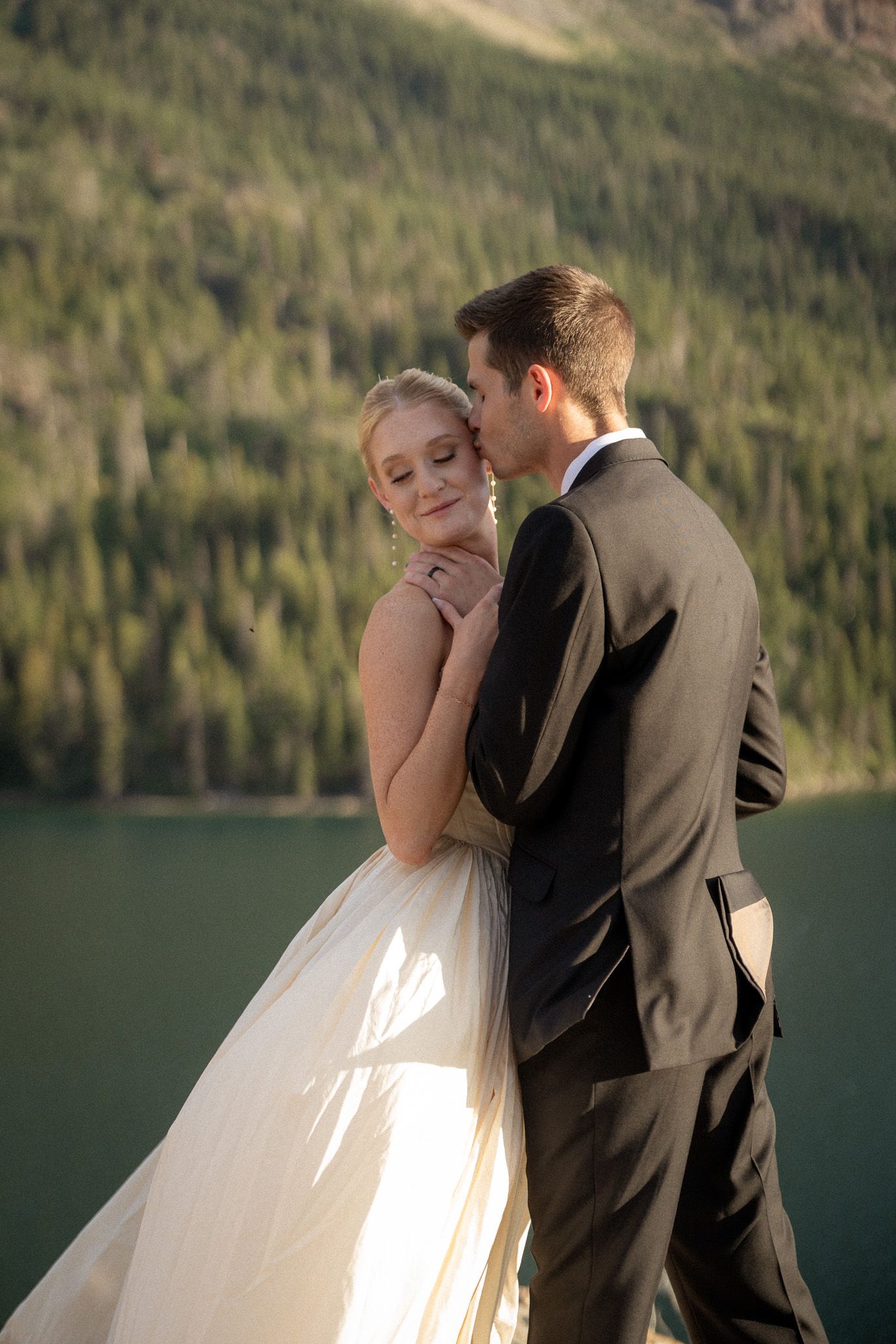 Bride and groom embrace at scenic location