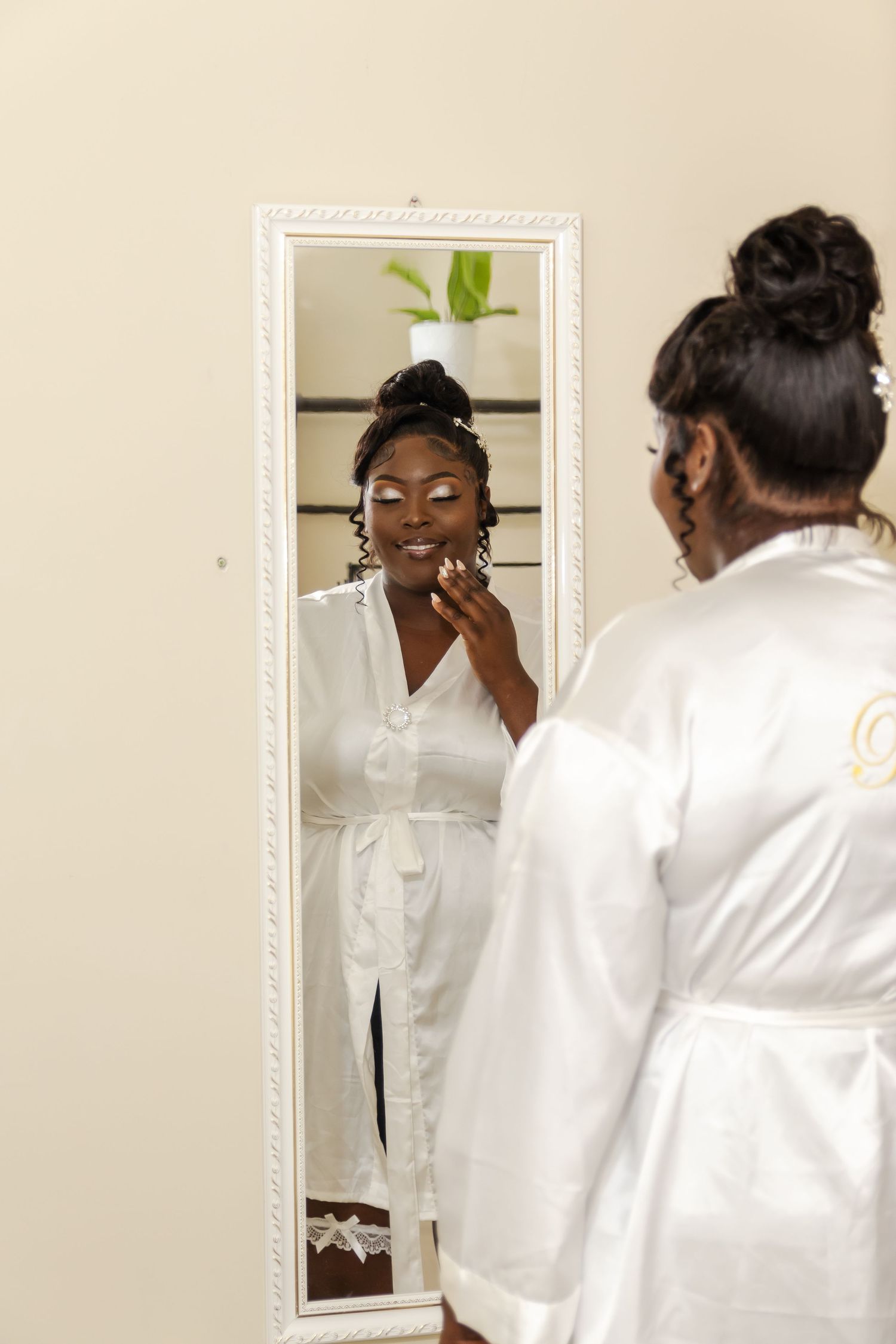 Beautiful bride standing infront of a mirror with eyes close so the wedding Photographer can take the photograph she's in a white bride robe