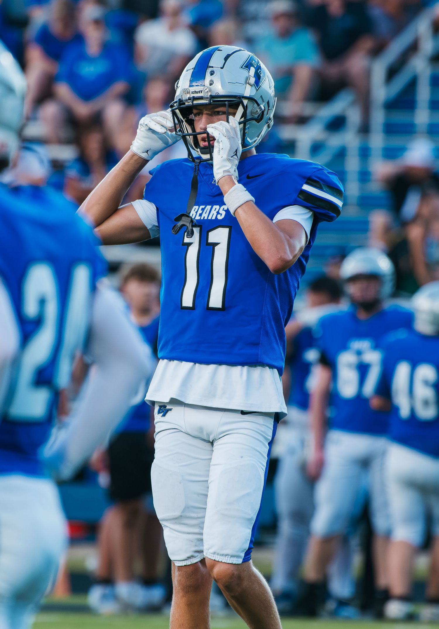 Football player #11 in blue Bears jersey and helmet gestures on field during a game.