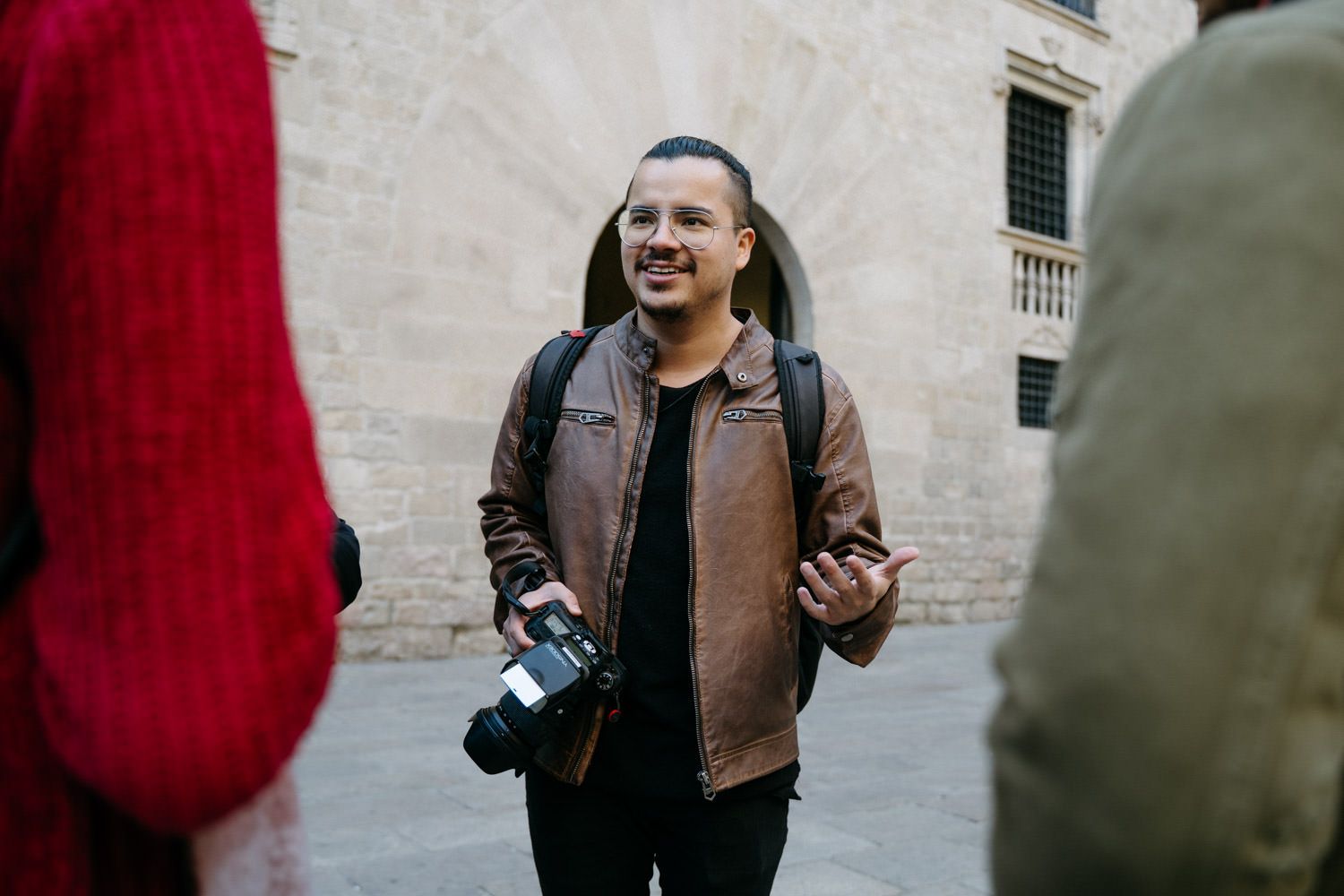 Photography session in progress with cameras and casual interactions near stone architecture.