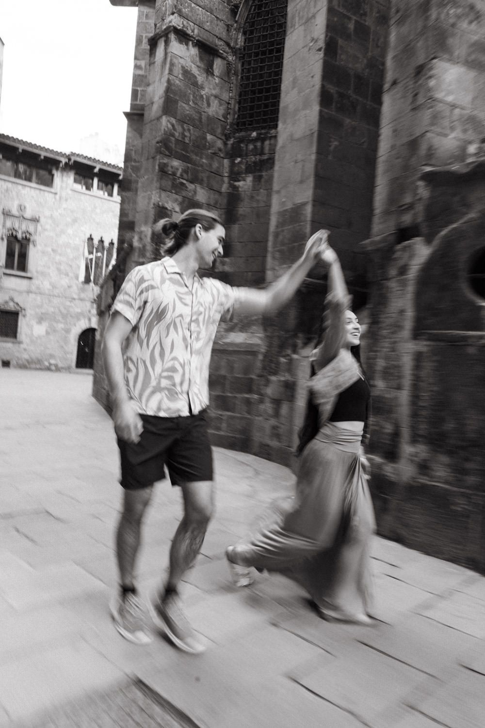 Dynamic dance performance captured in motion against historic stone building facade.