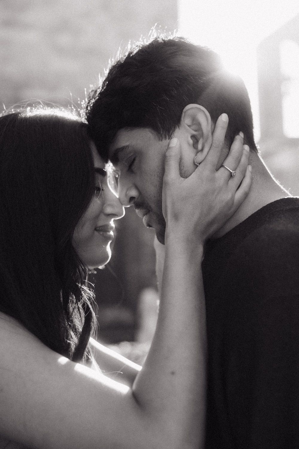 A romantic black and white photo series showing an intimate couple embracing in soft, backlit lighting.