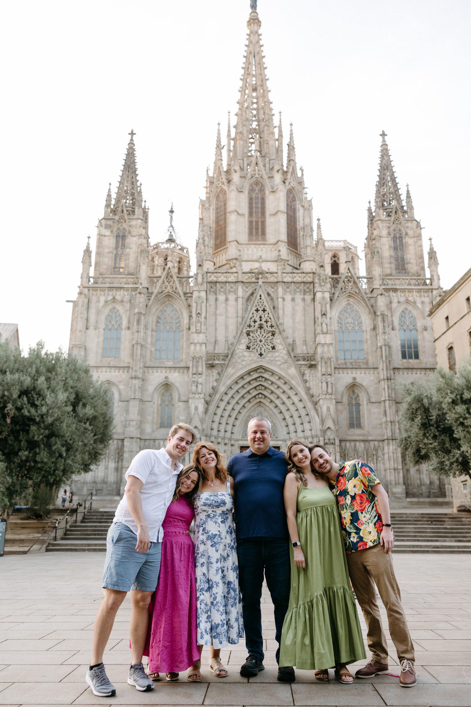 Group photo in front of Barcelona Cathedral's Gothic facade with ornate spires.