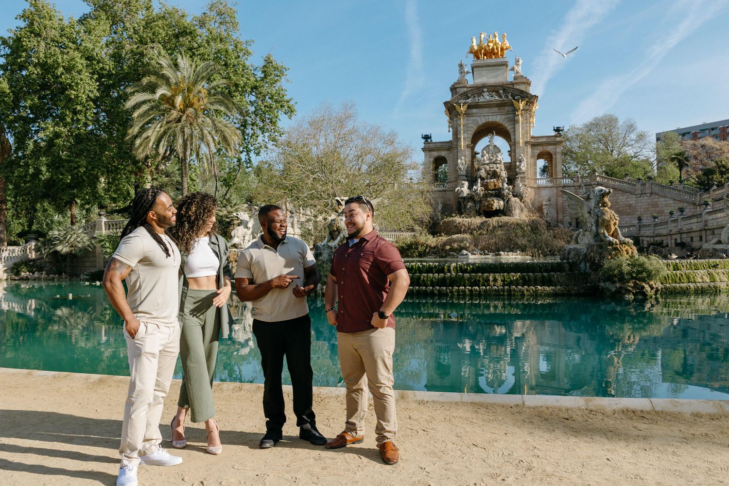 Palm trees and historic architecture reflected in tranquil pond at Barcelona's Parc de la Ciutadella.