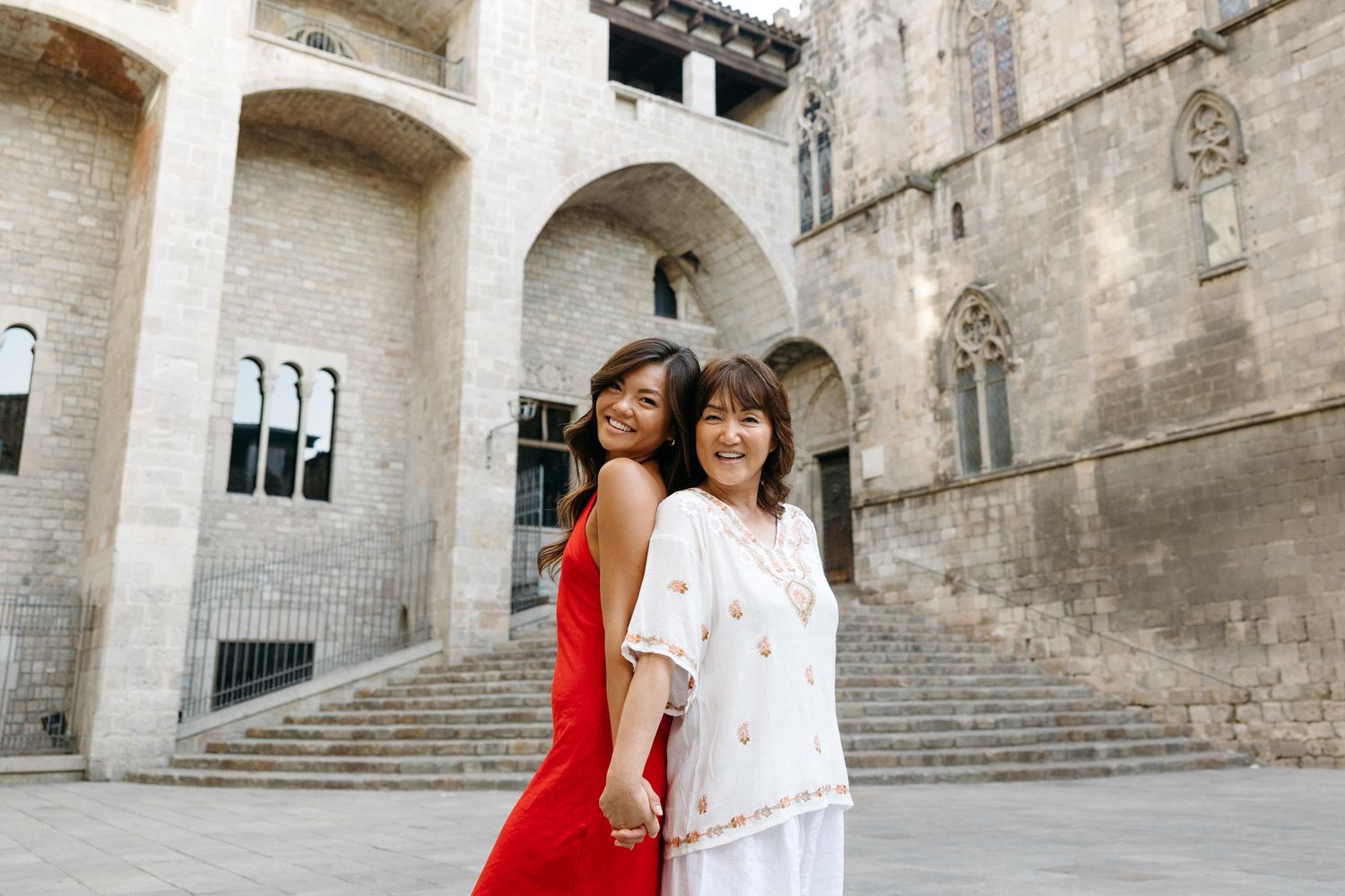 Romantic couple photoshoot in the historic Gothic Quarter of Barcelona with stone architecture backdrop.