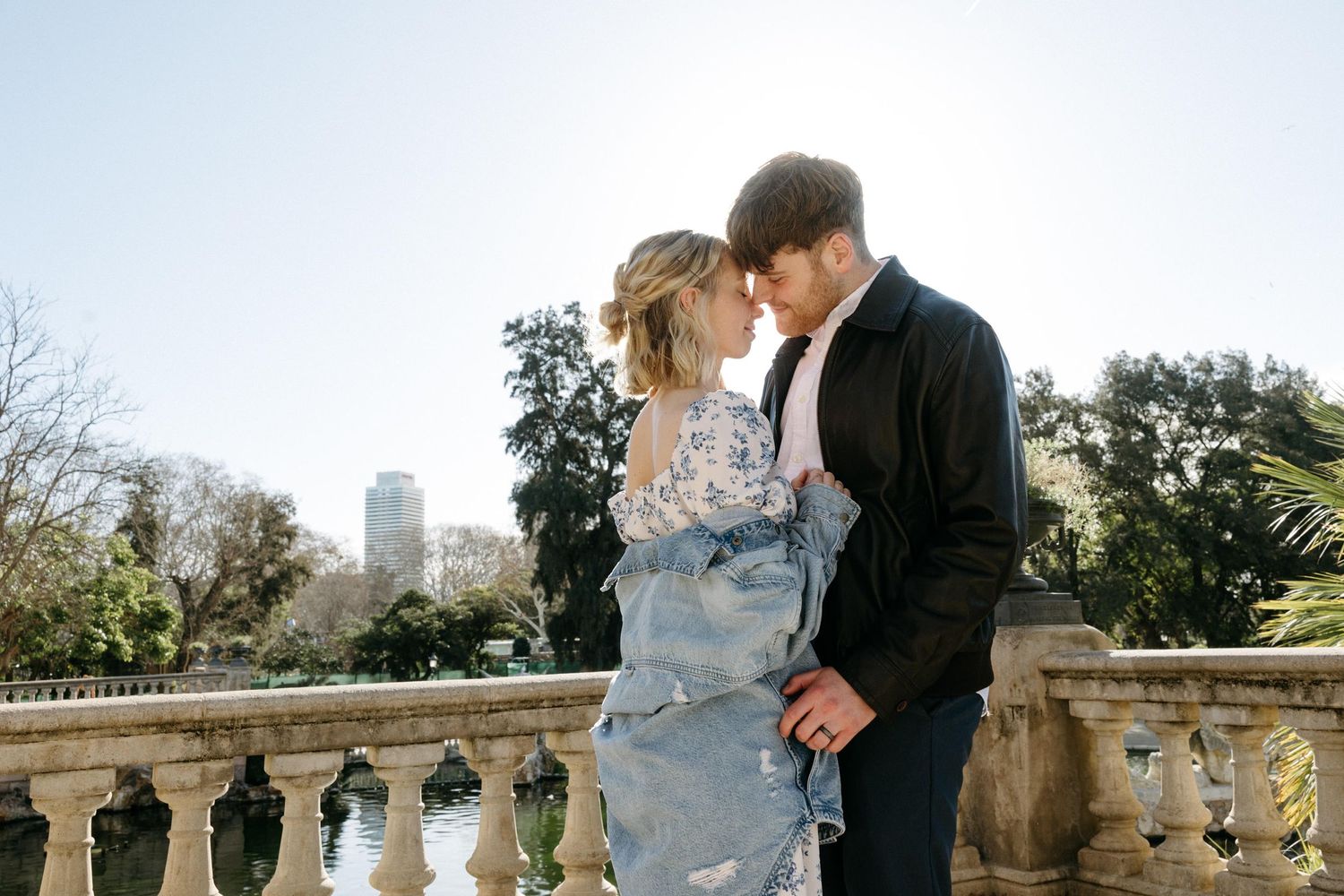 A romantic outdoor photoshoot with an elegant couple on a stone balcony.