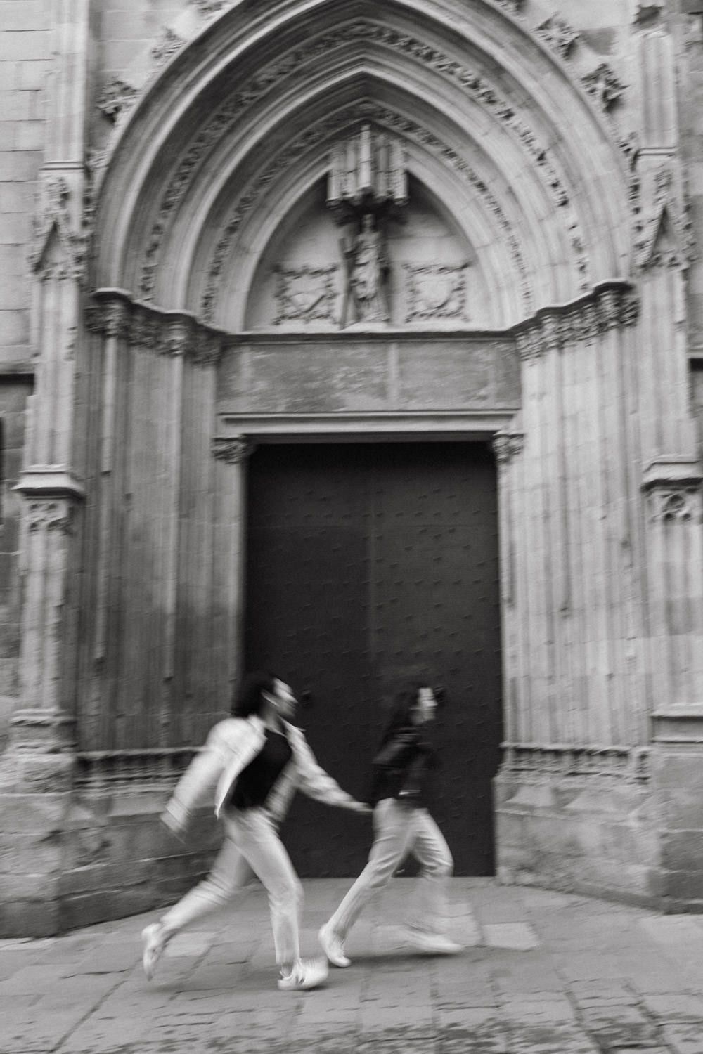 Motion blur sequence of couple dancing in front of Gothic cathedral doorways.