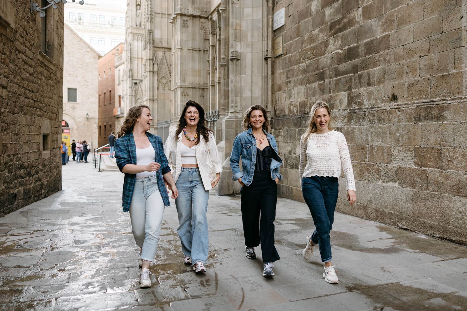 Friends walking together through the historic Gothic Quarter streets of Barcelona.