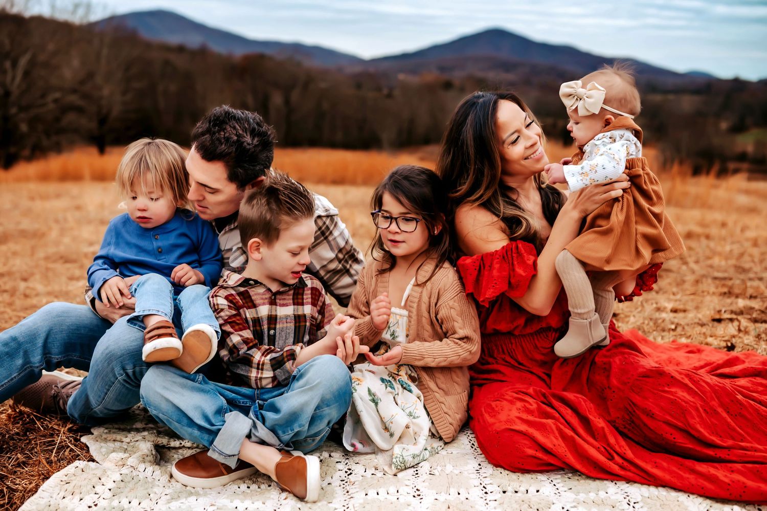 A series of candid outdoor family photos taken in a field during golden hour with mountains in the background.